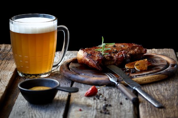 caneca de chop e um prato com carne.