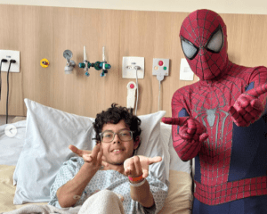 Paciente em leito hospitalar ao lado do homem-aranha.