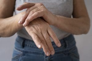 Mulher com dores articulares na mão
