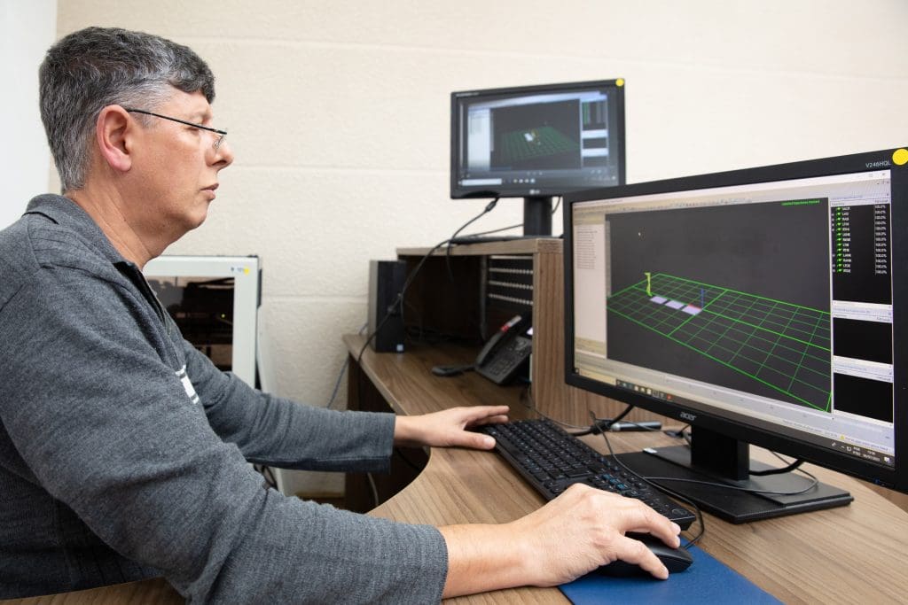 Profissional da AACD mexe em computadores do Laboratório de Marcha
