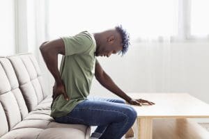 Homem com síndrome facetária com dor na coluna