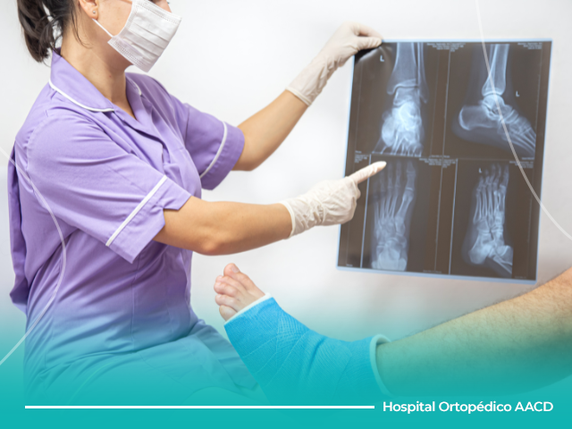 Médica mostra raio-x de pé quebrado para paciente.
