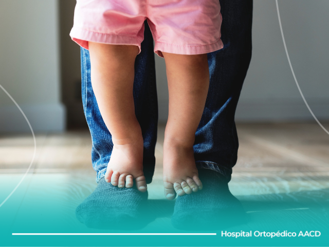 Pés de bebê descalços em cima de pés com meia.