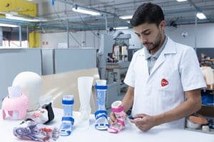 Profissional da AACD ajusta uma órtese em oficina ortopédica.