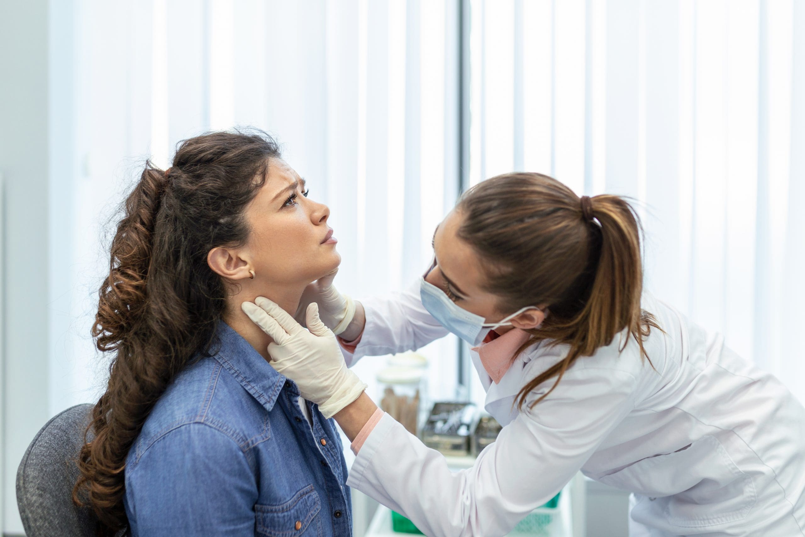 Mulher examinando a garganta da paciente